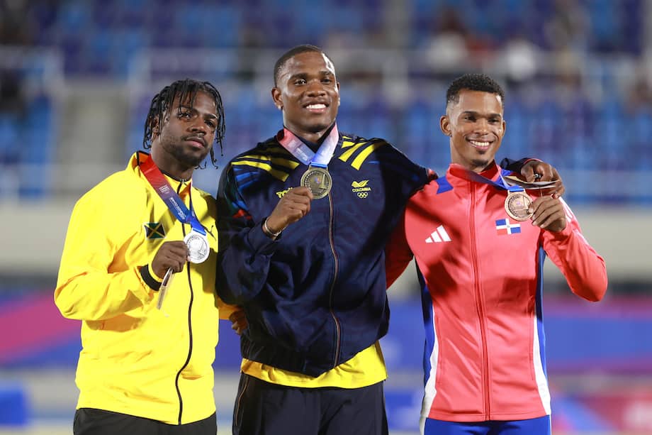 Ronal Longa (c) de Colombia, medalla de oro, Bouwahjgie Mkrumie (i) de Jamaica, medalla de plata, y Melbin Marcelino de República Dominicana, medalla de bronce, posan en la ceremonia de premiación de los 100 metros masculinos este lunes 3 de agosto, durante los XXV Juegos Centroamericanos y del Caribe Santo Domingo 2026, en República Dominicana.