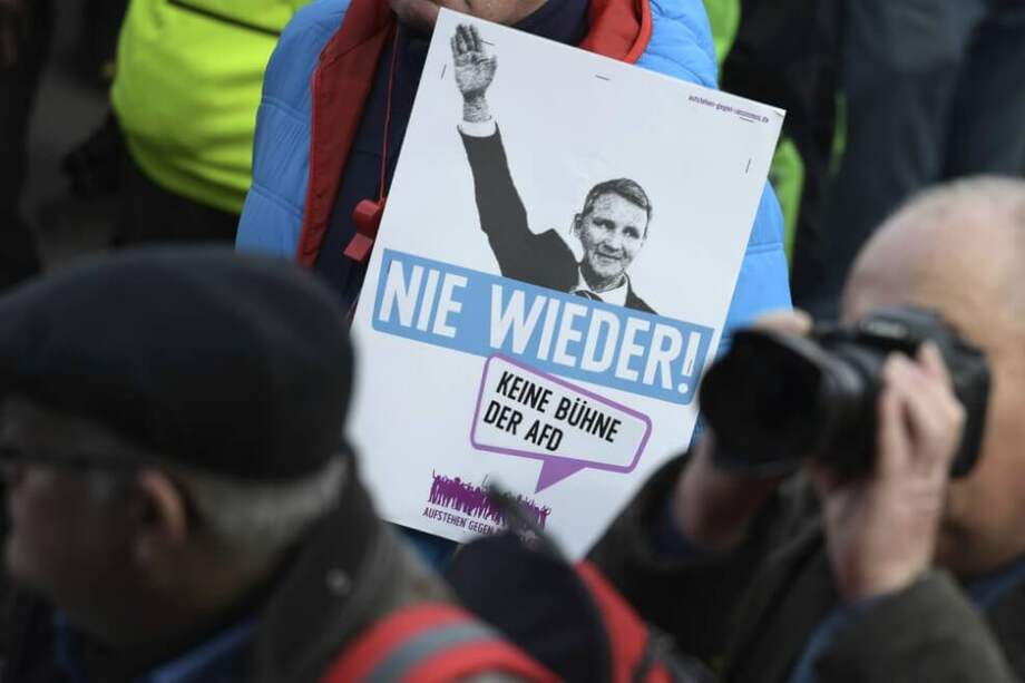 Un manifestante sostiene un póster que muestra a Bjoern Hoecke, líder del partido AfD en Turingia, levantando su brazo y subtituló "Nunca más". Fotografía del 15 de febrero. / AFP