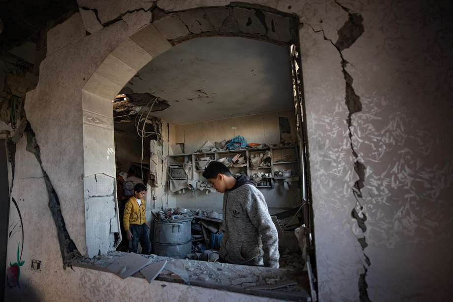 Un palestino inspecciona la casa dañada de su familia tras los ataques aéreos israelíes nocturnos sobre el campo de refugiados de Rafah, al sur de la Franja de Gaza.