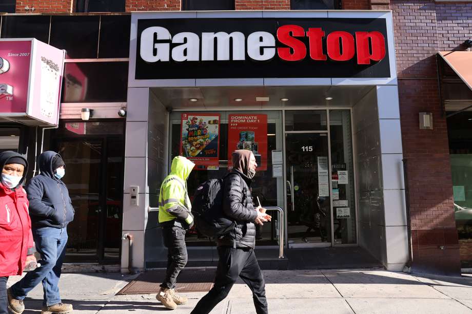 NEW YORK, NEW YORK - JANUARY 28: People walk by a GameStop store in Brooklyn on January 28, 2021 in New York City. Markets continue a volatile streak with the Dow Jones Industrial Average rising over 500 points in morning trading following yesterdays losses. Shares of the video game retailer GameStop plunged.   Spencer Platt/Getty Images/AFP