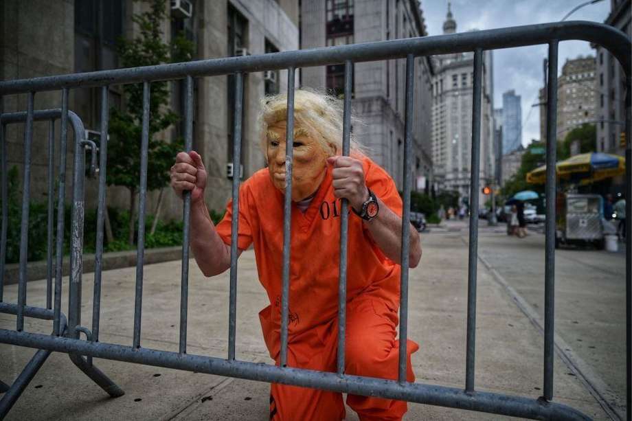 Un hombre disfrazado de Donald Trump, con un uniforme de prisión, posa a las afueras de la fiscalía de Manhattan.