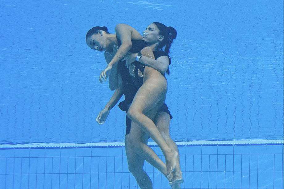 A member of Team USA (R) recovers USA's Anita Alvarez (L), from the bottom of the pool during an incident in the women's solo free artistic swimming finals, during the Budapest 2022 World Aquatics Championships at the Alfred Hajos Swimming Complex in Budapest on June 22, 2022. (Photo by Oli SCARFF / AFP)