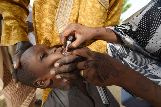Un trabajador de salud administra una vacuna a un niño durante una campaña de vacunación contra el polio en el noroeste de Nigeria, en 2017.