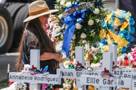 Una mujer se arrodilla entre los nombres de las víctimas tras el tiroteo masivo en la Escuela Primaria Robb en Uvalde, Texas, EE. UU.