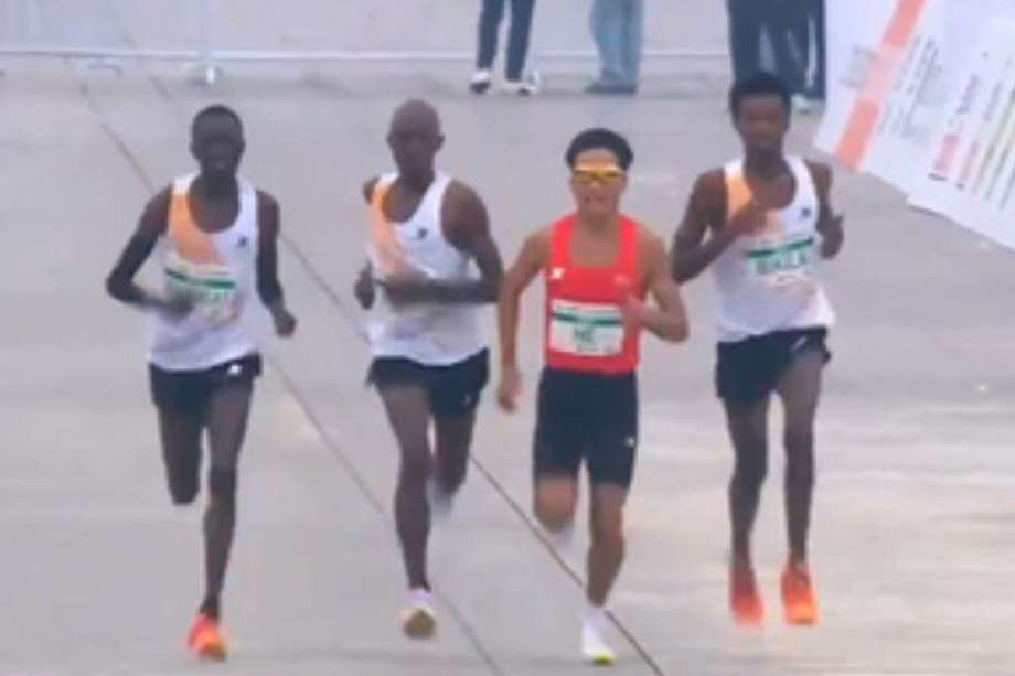 He Jie (de naranja) junto a los tres atletas africanos que terminaron a su lado en la Media Maratón de Pekín 2024.