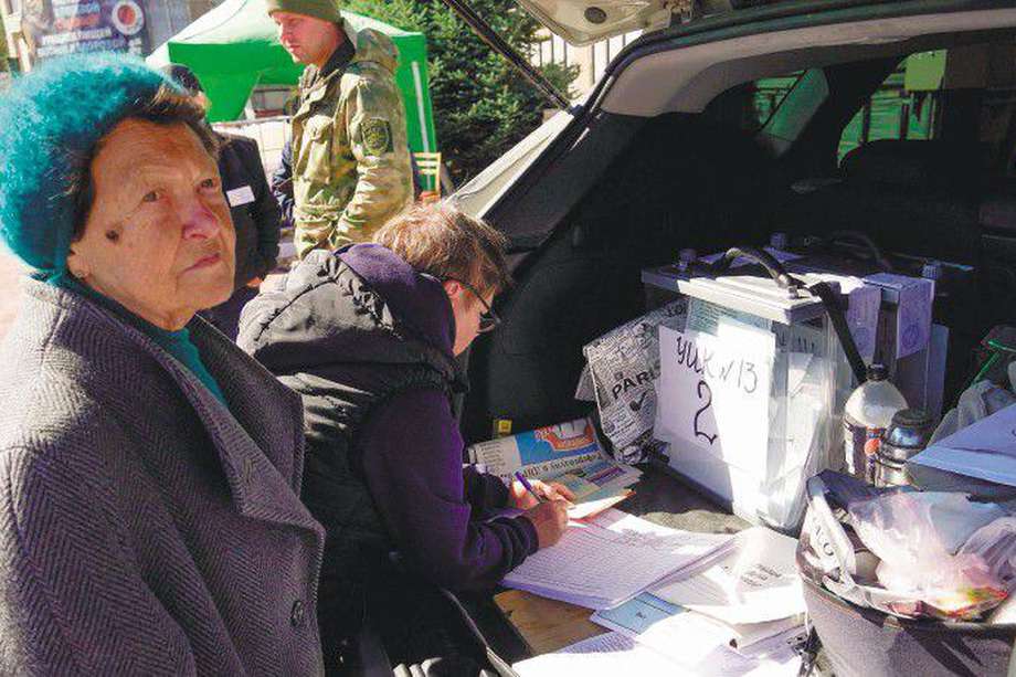 Un grupo de mujeres asiste a una mesa de votación móvil en Mariúpol (Ucrania). / AFP