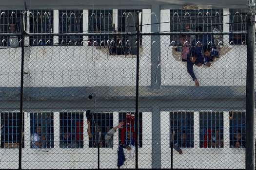 Reclusos se asoman en ventanas este domingo luego de un motín, en la cárcel Modelo de Bogotá (Colombia). 