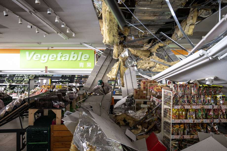 Un hombre limpia los escombros de un techo dañado en un supermercado en Shiroishi, el 17 de marzo de 2022, después de que un terremoto sacudiera el este de Japón la noche anterior.