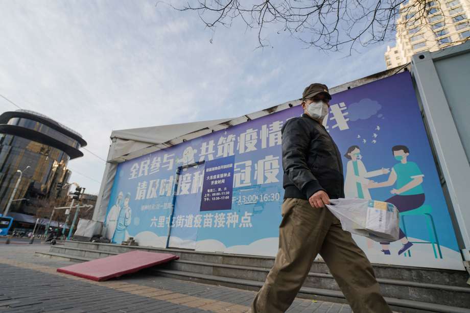 Un hombre con mascarilla camina junto a un sitio de vacunación en Beijing, China, el 7 de diciembre de 2022.