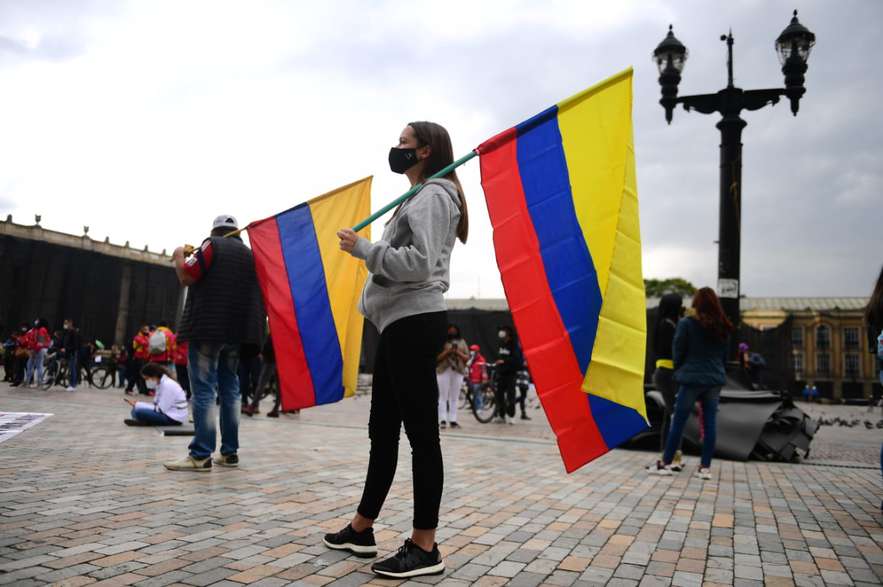 Una mujer de perfil con una bandera de Colombia