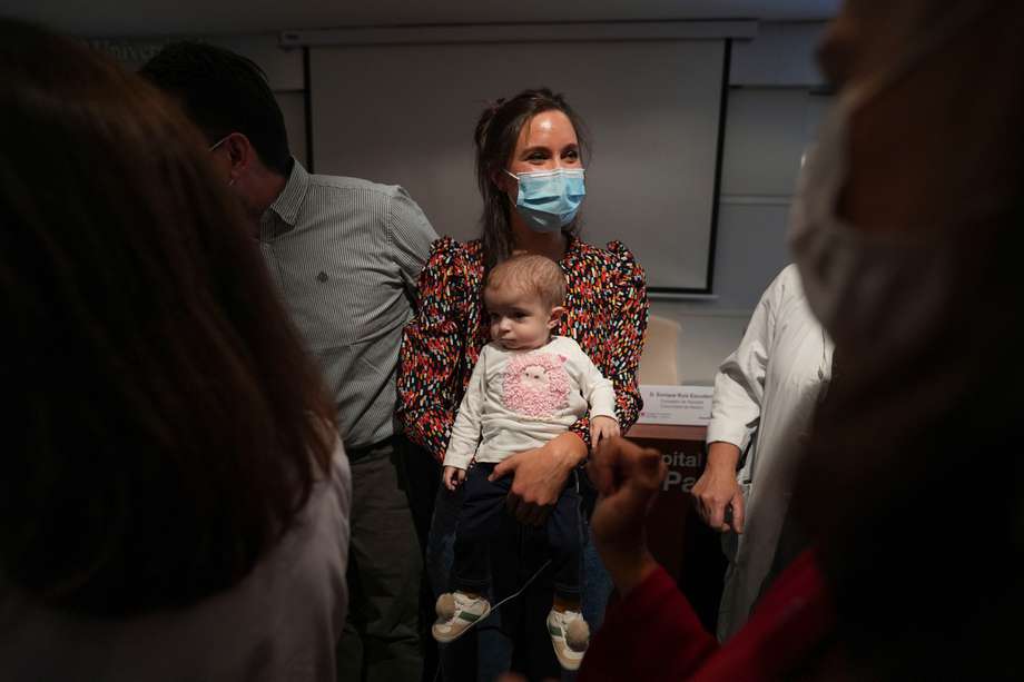 Emma, de 13 meses, en brazos de su madre, Ana. El procedimento se realizó en el hospital público madrileño de La Paz. 
