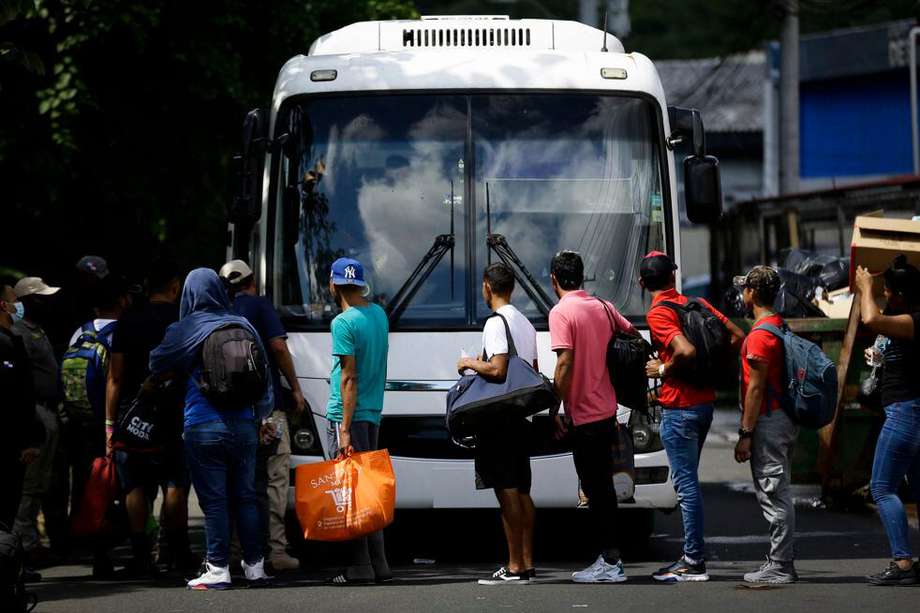 Migrantes latinoamericanos abordando un autobús.