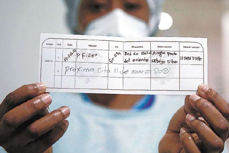 Una enfermera muestra el carné que identifica que recibió la primera dosis de la vacuna contra la covid-19 hoy, en la Clínica Unidos por la Vida en Cali (Colombia).  EFE/ Ernesto Guzmán Jr