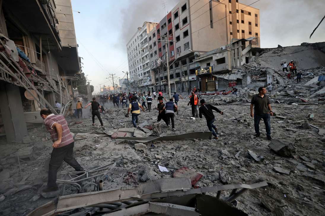 Los enfrentamientos entre los grupos armados palestinos en la Franja de Gaza e Israel ya han causado al menos 70 muertos y provocaron este miércoles la movilización de la comunidad internacional para evitar una "guerra a gran escala". En esta foto, los rescatistas y las personas se reúnen entre los escombros frente a la torre Al-Sharouk que se derrumba después de ser golpeada por un ataque aéreo israelí, en la ciudad de Gaza, el 12 de mayo.