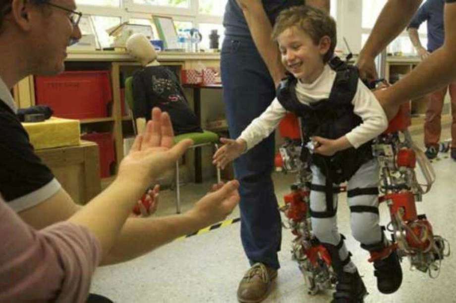 Álvaro, de cinco años y afectado por atrofia muscular espinal, camina hacia sus padres durante una prueba del exoesqueleto. / Joan Costa – CSIC - SINC