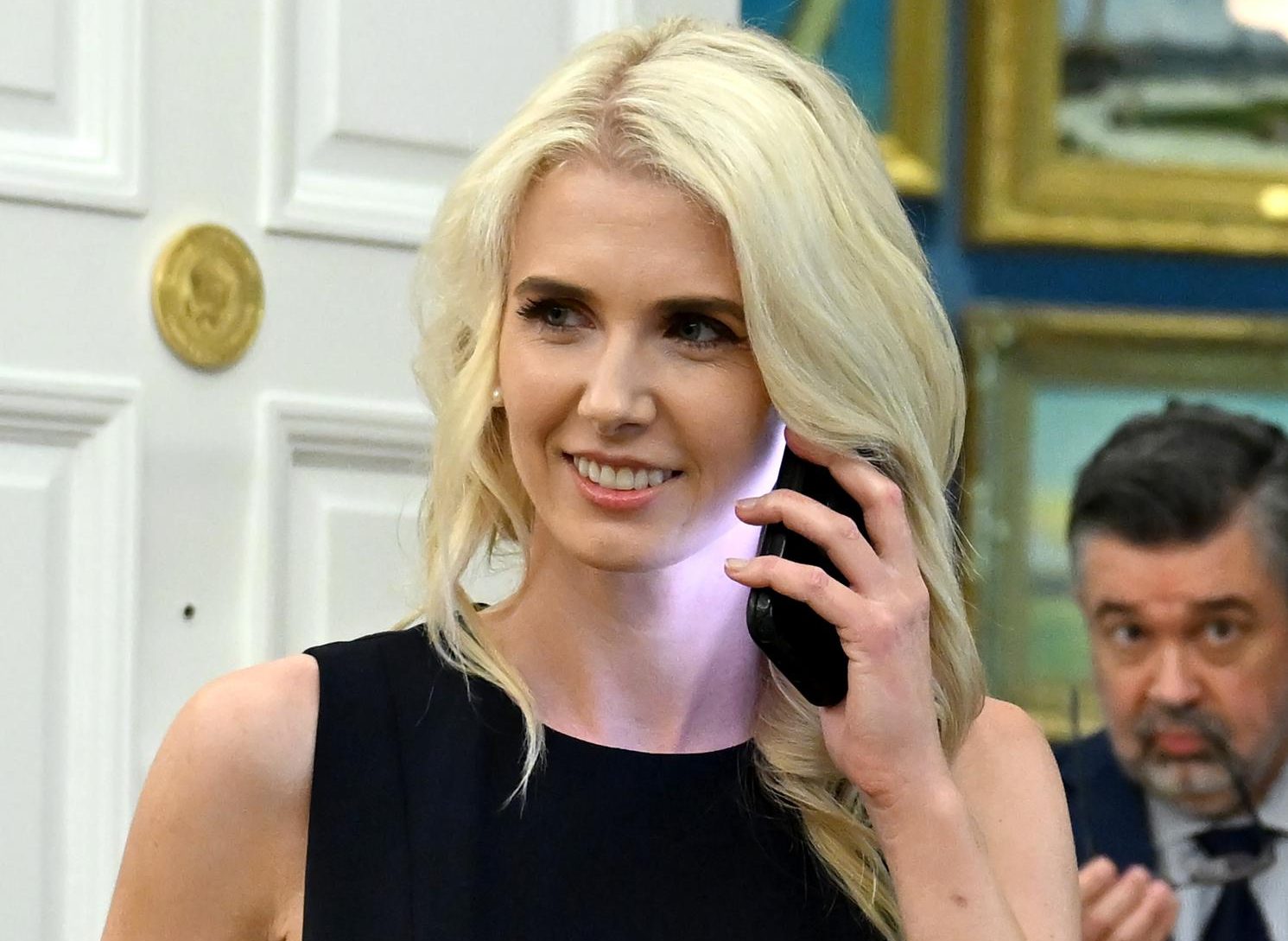 Washington (United States of America), 31/08/2026.- Natalie Harp, Executive Assistant to the President, speaks on a smartphone as United States President Donald J Trump hosts an announcement on healthcare affordability in the Oval Office of the White House in Washington, DC, USA, 31 August 2026. (Estados Unidos) EFE/EPA/Annabelle Gordon / POOL