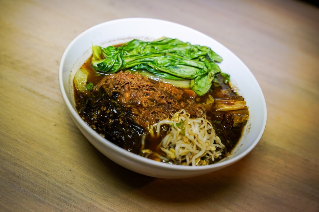 Propuesta de ramen en Amen Ramen con caldo de res, especias, costilla, bok choi, cebollas tatemada y kombu marinado.