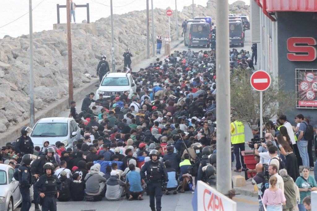 CEUTA, 18/09/2026.- Traslado de migrantes asentados en la playa de Benítez, este viernes. Las autoridades han iniciado a primera hora de este viernes el traslado de los migrantes asentados en las playas de Benítez y el Trampolín de Ceuta hasta el campamento temporal habilitado en el puerto de la ciudad, con capacidad para unas 1.700 personas. Un amplio dispositivo policial se ha desplegado en torno a las 7:15 de la mañana en ambos asentamientos, donde permanecen adultos y menores desde la entrada masiva registrada el pasado 30 de julio. EFE/Reduan