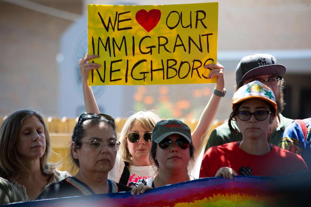 AME9542. AUSTIN (ESTADOS UNIDOS), 21/09/2026.- Una mujer sostiene un cartel este lunes en el lugar donde un inmigrante venezolano recibió un disparo por la espalda de un agente del ICE el pasado domingo en Austin (Estados Unidos). El Departamento de Seguridad Nacional de EE.UU. (DHS, por sus siglas en inglés) confirmó a EFE la apertura de una investigación sobre el incidente en el que un inmigrante venezolano resulto gravemente herido por un agente del ICE. EFE/ Carlos Ramírez