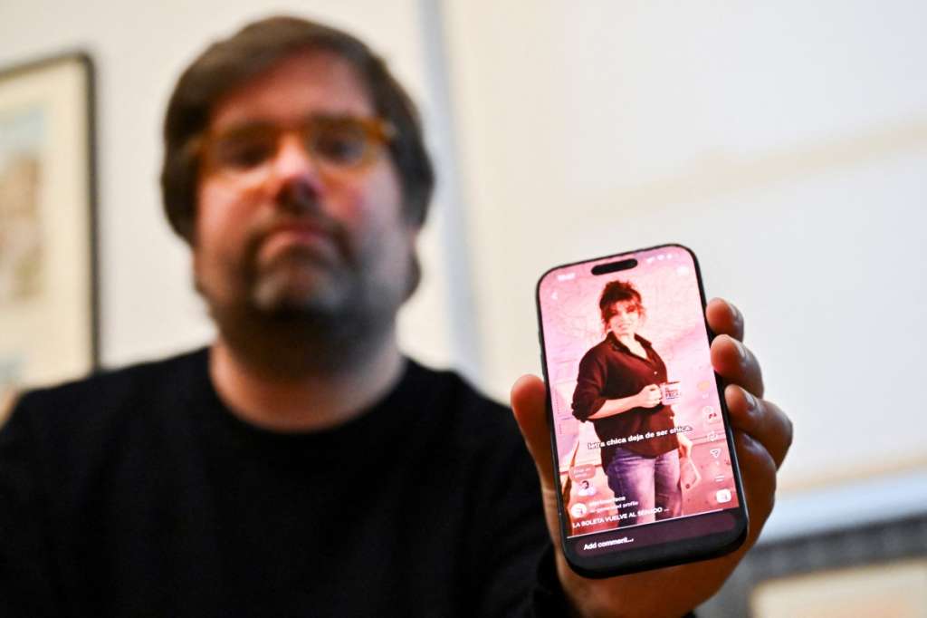Santiago Siri, 42, an Argentine software developer and creator of "El Primer Feca" ("coffee" spelled backwards), an Argentine news outlet produced entirely by artificial intelligence using journalist avatars, shows the platform on his mobile phone during an interview with AFP in Buenos Aires on September 18, 2026.