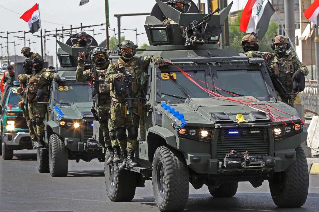 Baghdad (Iraq), 30/09/2026.- Iraqi security officers flash victory signs while riding military vehicles decorated with national flags during a convoy celebrating the complete withdrawal of US troops from Iraq, in Baghdad, Iraq, 30 September 2026. After nearly 23 years in Iraq, the US-led coalition closes and hands over its bases to the Iraqi government. The Iraqi government has announced three days of celebrations to mark 'Sovereignty Days' from 30 September until 03 October. (Bagdad) EFE/EPA/CEERWAN AZIZ