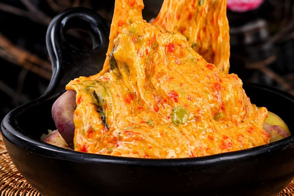 La cebolla larga y el tomate son los dos ingredientes infaltables en estas papas chorreadas.