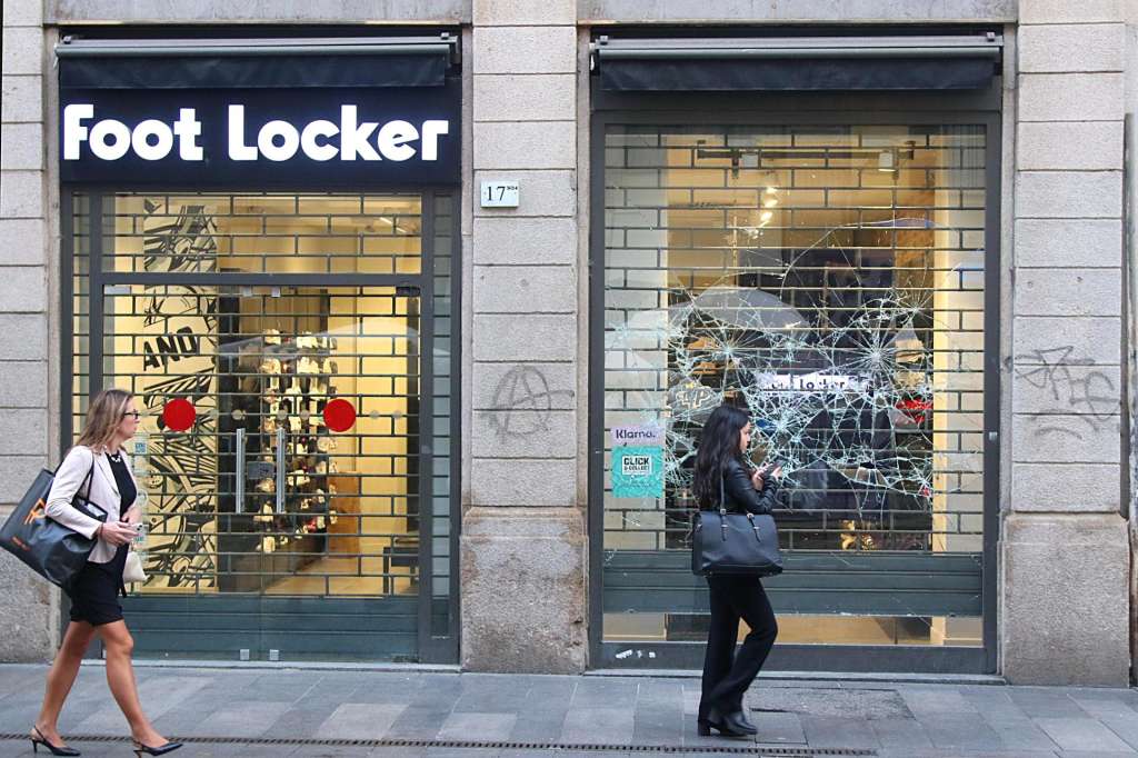 MILAN (Italy), 19/10/2026.- People walk past at a smashed store window following two days of youth riots, in Milan, Italy, 19 October 2026. Riots on the sidelines of a cost-of-living protest over the weekend caused extensive damage in Milan. (Protestas, Disturbios, Italia) EFE/EPA/PAOLO SALMOIRAGO