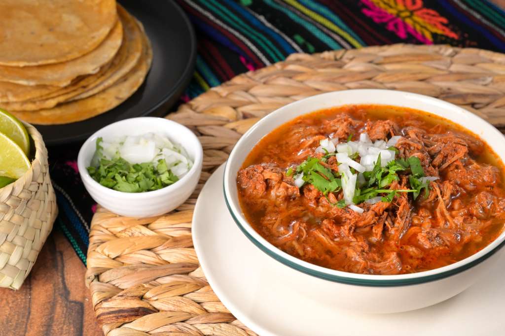 La birria es un estofado de diferentes cortes de res, especias y chiles, cocinado a fuego lento durante varias horas.