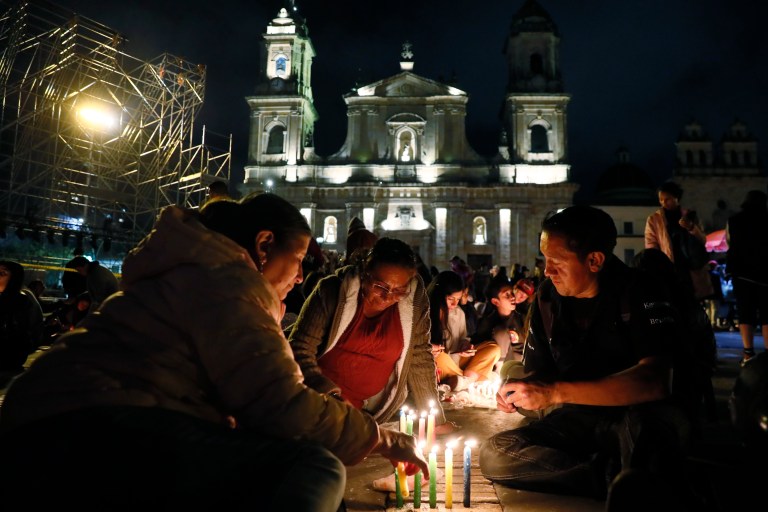 -FOTODELDÍA- AME2774. BOGOTÁ (COLOMBIA), 07/12/2023.- Personas encienden velas durante la tradicional noche de las velitas hoy, en la Plaza de Bolívar en Bogotá (Colombia). Los colombianos celebraron este jueves la tradicional noche de las velitas que marca el inicio de las conmemoraciones navideñas. EFE/Carlos Ortega