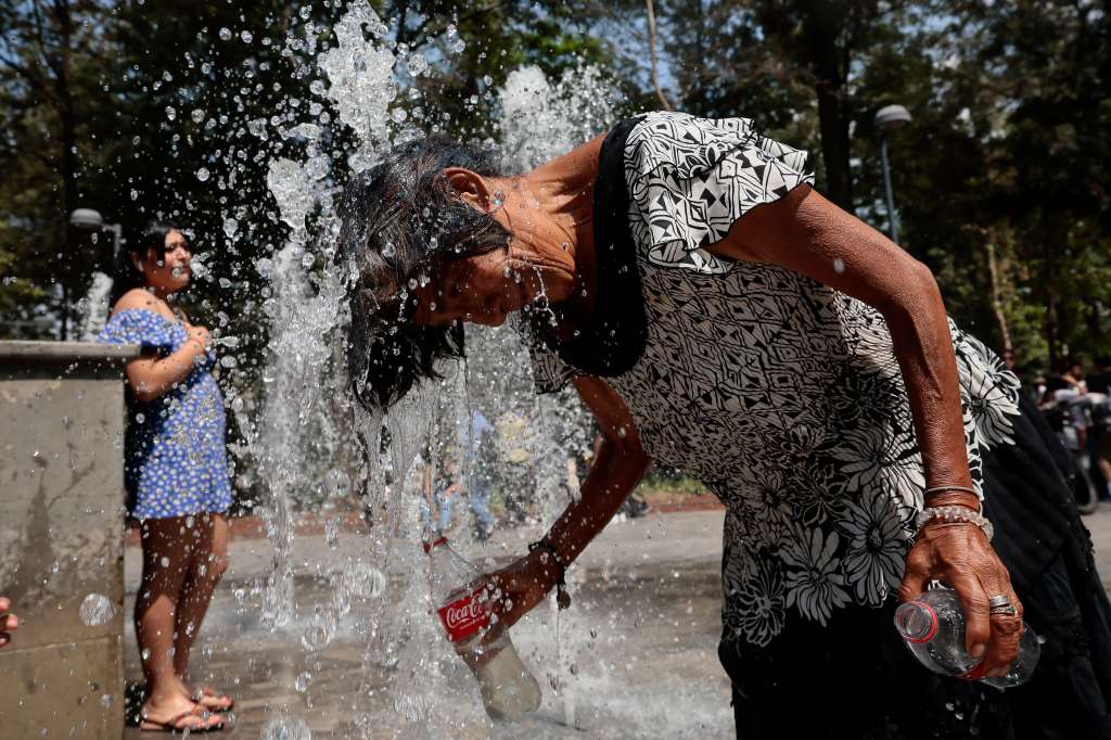 MEX8878. CIUDAD DE MÉXICO (MÉXICO), 26/05/2024.- Una mujer se refresca en una fuente pública, el 24 de mayo de 2024, debido a las altas temperaturas registradas en la Ciudad de México (México). Más de la mitad de los 32 estados de México, 19, registrarán este domingo temperaturas superiores a los 45 grados Celsius, debido la tercera onda de calor de la temporada que afecta al territorio mexicano, informó el Servicio Meteorológico Nacional (SMN).
 EFE/José Méndez
