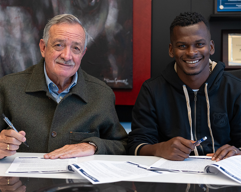 Carlos Darwin Quintero firmando su contrato como jugador de Millonarios junto a Enrique Camacho, presidente del club.