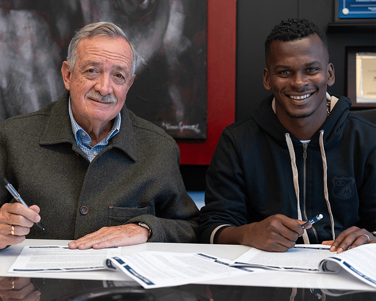 Carlos Darwin Quintero firmando su contrato como jugador de Millonarios junto a Enrique Camacho, presidente del club.