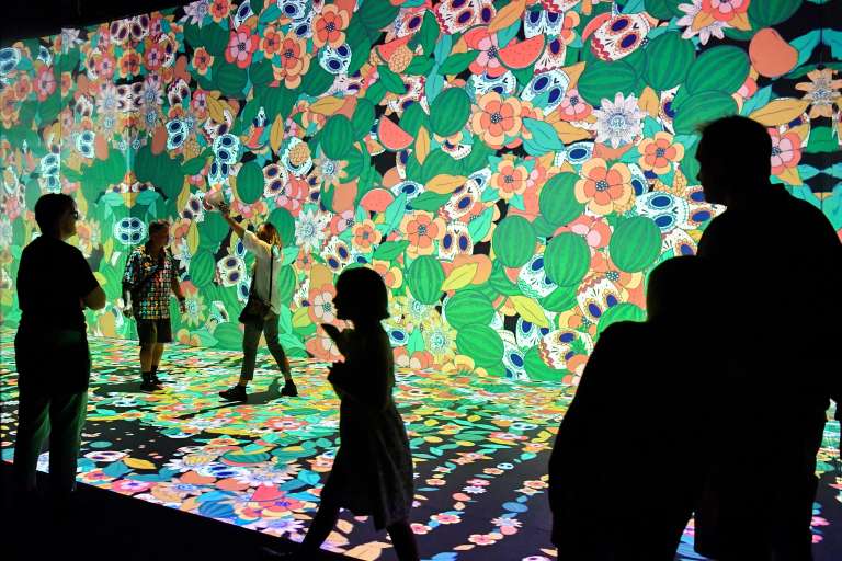 Varias personas interactúan con las imágenes que forman parte de "Frida Kahlo: La vida de un icono", dentro del Festival de Sídney 2023.