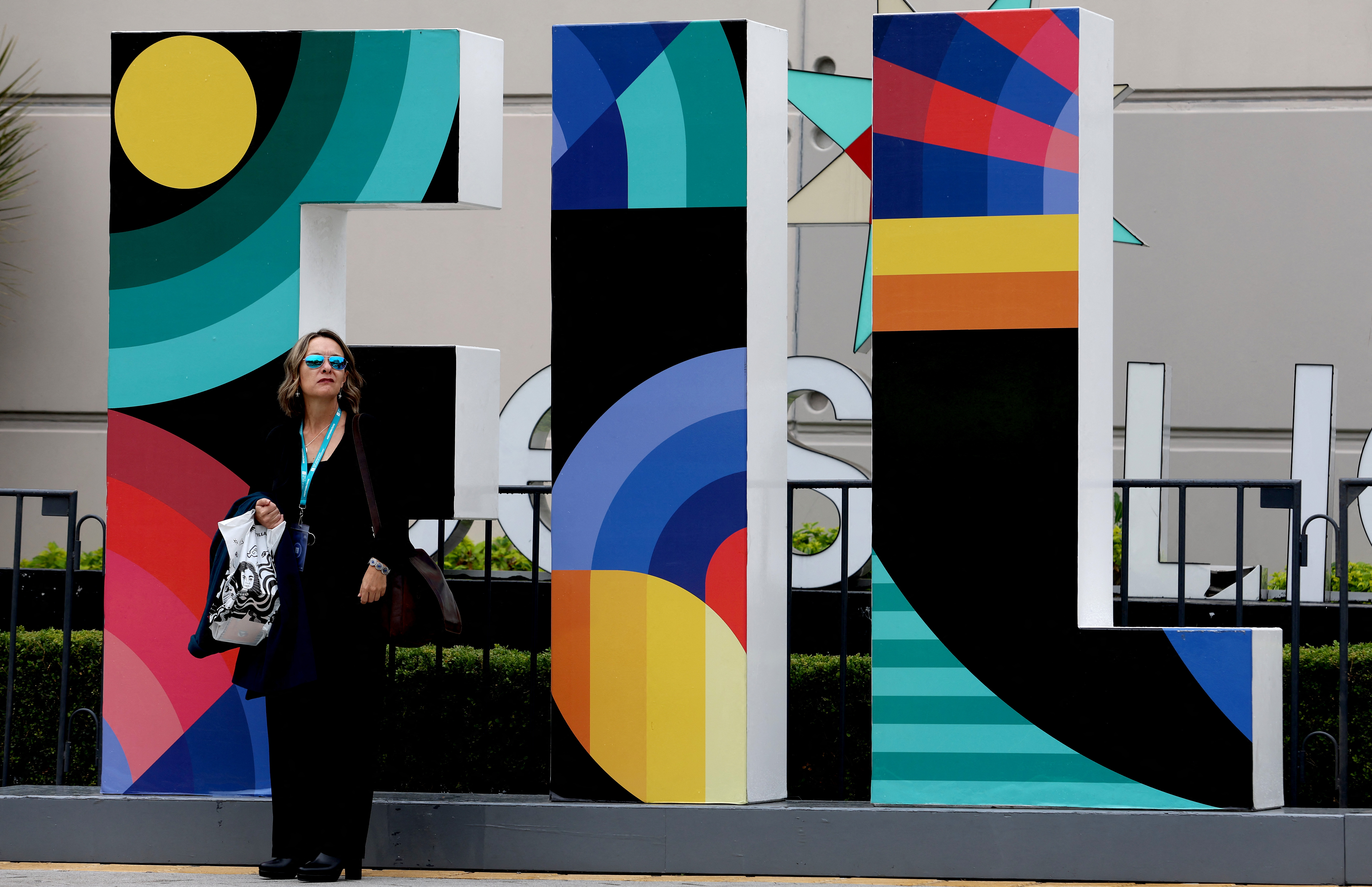 A woman waits in front of a FIL (Feria International del Libro) sign on the third day of the Guadalajara International Book Fair in Guadalajara, Mexico, on November 27, 2023. The Guadalajara International Book Fair runs until December 3, with the European Union as guest of honour. (Photo by ULISES RUIZ / AFP)