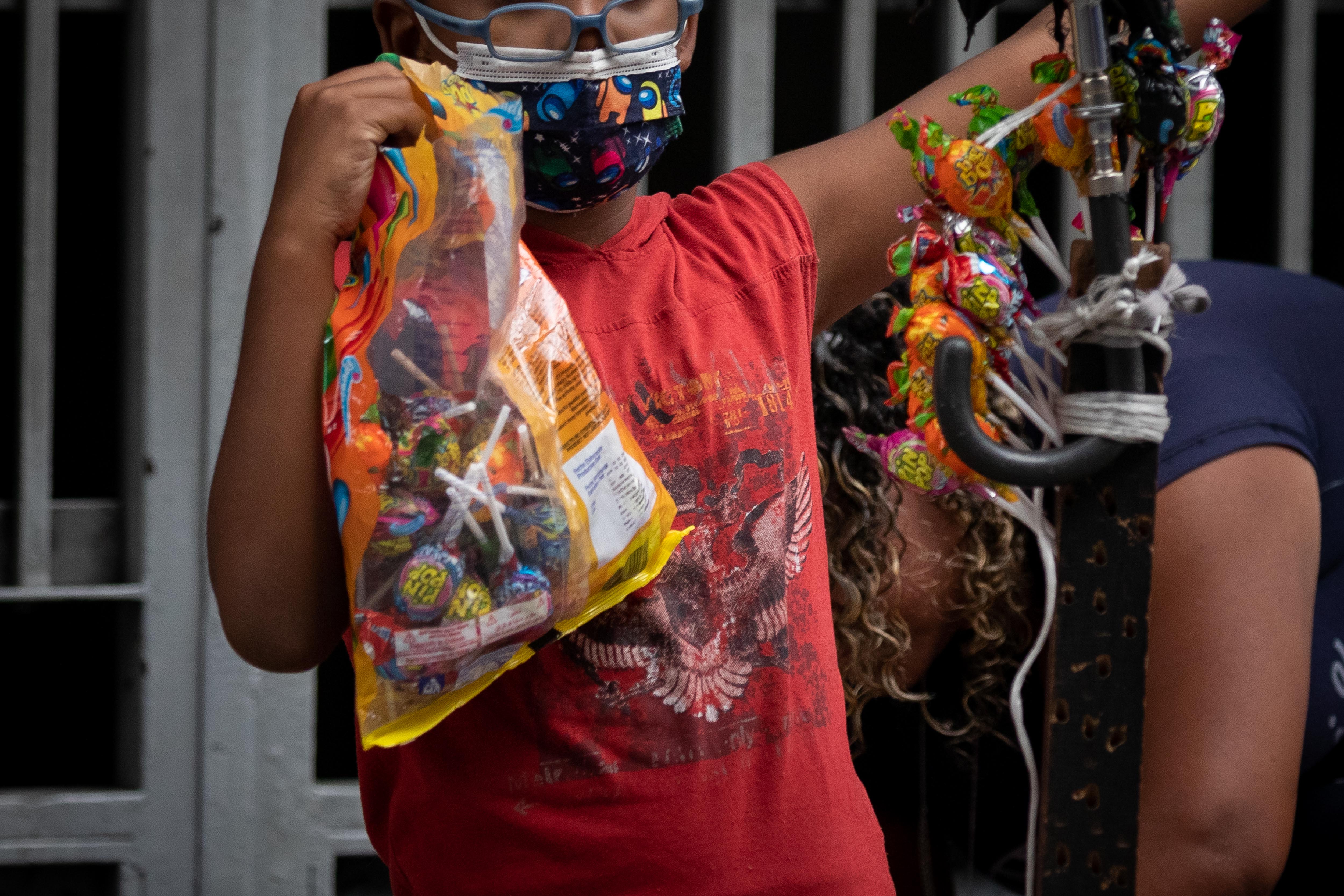 AME6246. CARACAS (VENEZUELA), 12/06/2022.- Un niño trabaja en un puesto informal de venta de golosinas, el 10 de junio de 2022, en Caracas (Venezuela). La crisis económica, el cierre de las escuelas por la pandemia y la violencia son algunos de los factores que han empujado a muchos niños en Venezuela a trabajar, un problema "invisibilizado", según expertos, por la falta de cifras oficiales que permitan conocer su alcance real. El director de la ONG Centros Comunitarios de Aprendizajes (Cecodap), Carlos Trapani, indicó que una primera dificultad que existe es que no hay cifras oficiales para saber cuántos jóvenes están laboralmente activos. EFE/ Rayner Peña R.