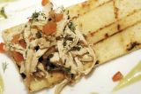 Pollo desmechado sobre galleta de maíz con salsa de aguacate