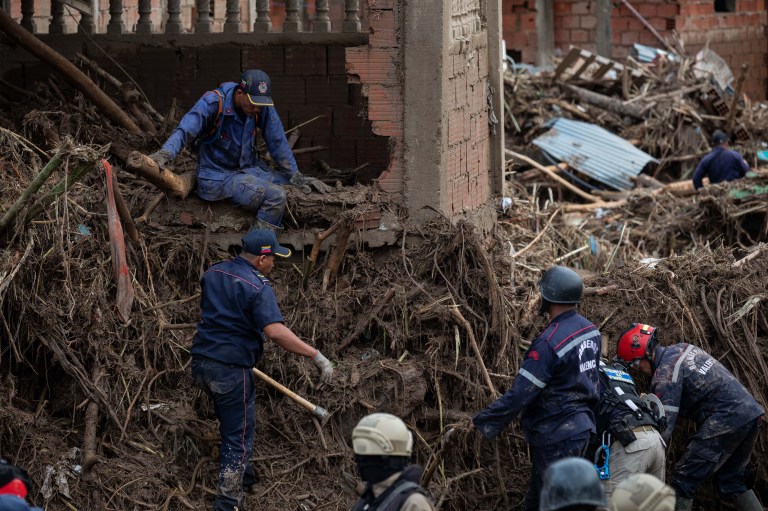 ACOMPAÑA CRÓNICA: VENEZUELA LLUVIAS***AME3304. LAS TEJERÍAS (VENEZUELA), 09/10/2022.- Rescatistas buscan hoy a los desaparecidos entre los escombros tras el desbordamiento de la quebrada Los Patos, en Las Tejerías, estado Aragua (Venezuela). Algunos habitantes de Las Tejerías, en la zona central de Venezuela, recuerdan este domingo los gritos de la tragedia, mientras otros son incapaces de describir la noche del sábado, cuando esta pequeña ciudad fue arrasada por una quebrada desbordada, que se llevó a más de un centenar de personas, de las que, al menos, 25 murieron y más de 50 siguen desaparecidas. EFE/ Rayner Peña R