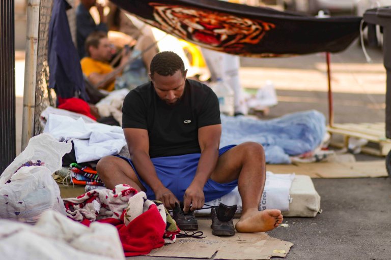 USA6879. EL PASO (TX, EEUU), 09/0572023.- Un migrante alista sus zapatos el lunes 8 de mayo de 2023 en las afueras de la Iglesia de Sagrado Corazón de Jesús, en El Paso, Texas (EE.UU.). Ante el inminente levantamiento del Título 42 en Estados Unidos, el próximo jueves, que ha permitido hasta ahora la expulsión inmediata de los migrantes por motivos sanitarios, miles de personas han comenzado ya a cruzar la frontera y otras esperan hacerlo en los próximos días. EFE/ Jonathan Fernández