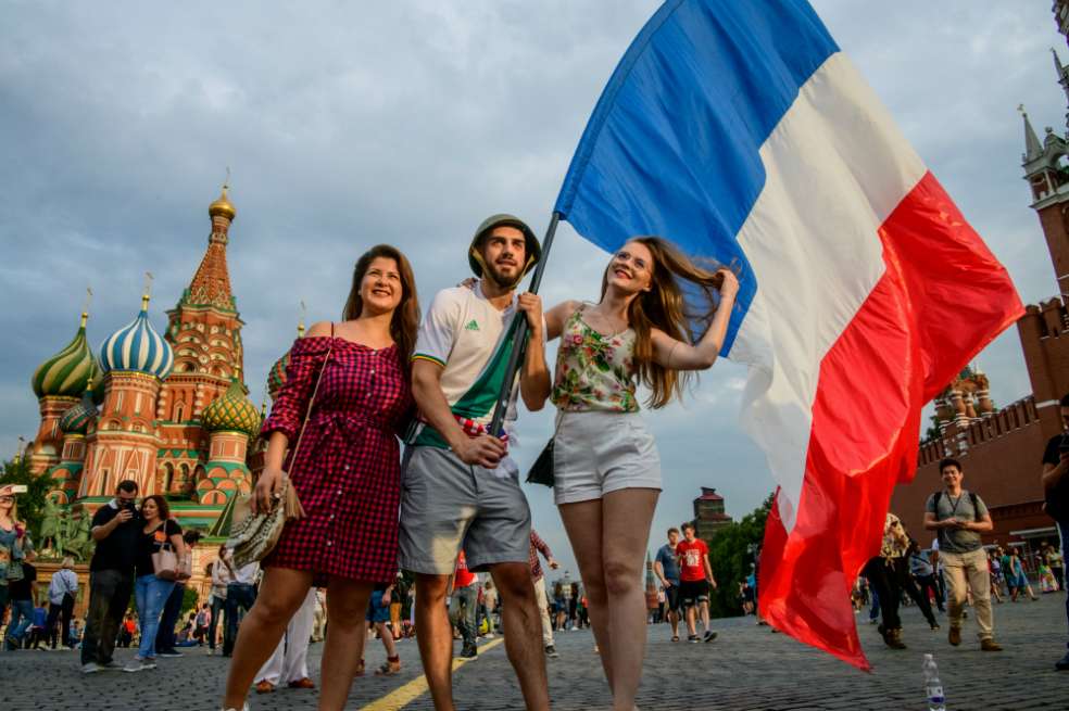 Seguidores del equipo francés sostienen una bandera del país frente a la Plaza Roja en Moscú, Rusia. / AFP