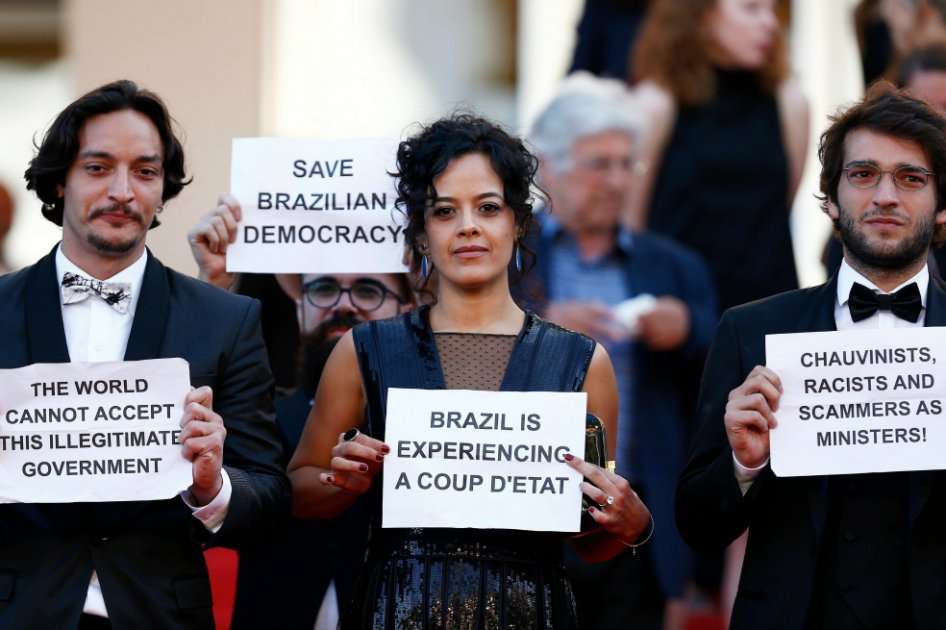 La actriz brasileña Maeve Jinkings (c) con un cartel en el que se puede leer "Brasil está sufriendo un golpe de estado", durante el Festival de Cine Internacional de Cannes. / EFE