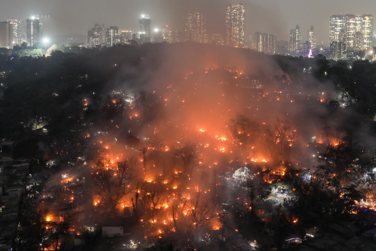 -FOTODELDÍA-  MUMBAI (INDIA), 13/03/2023.- El de un incendio se eleva entre pavesas y restos calcinados tras el incendio que se originó en una zona de barrios marginales de Appapada en Mumbai, India, este lunes. Hasta el momento no se han reportado heridos ni pérdidas de vidas. EFE/ Divyakant Solanki