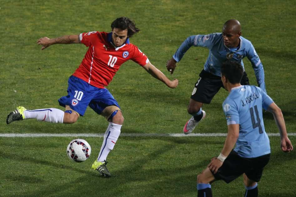 Jorge Valdivia intenta pasar entre Carlos Sánchez y Fucile. Foto: AFP