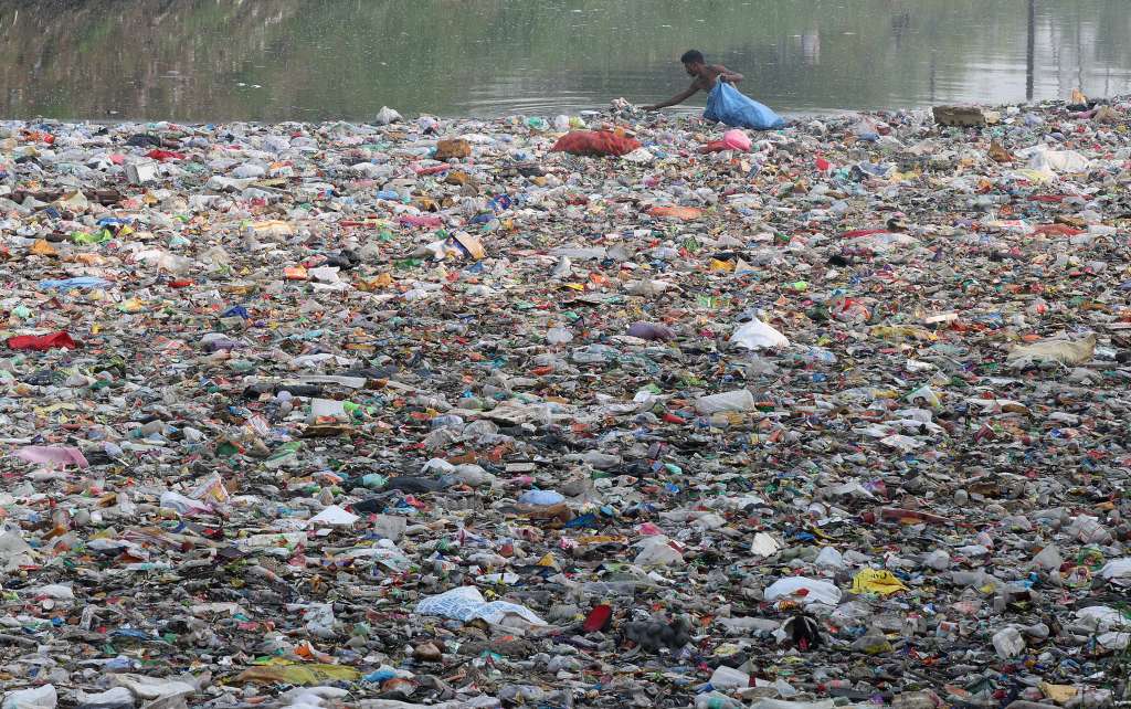 Nueva Delhi (India), 11/07/2024.- Un hombre recoge plástico reciclable y botellas de un canal lleno de basura doméstica y plástico, durante el Día Mundial de la Población en las afueras de Nueva Delhi, India, este jueves. Según el Foro Económico Mundial, India enfrenta desafíos crecientes en el tratamiento de aguas residuales a medida que su población crece, especialmente su infraestructura pública de agua, con más del 70% de las aguas residuales sin tratar. Los datos del Fondo de Población de las Naciones Unidas (UNFPA) muestran que la población de India se estima en 1.441 millones, superando a China como la nación más poblada del mundo. EFE/ Harish Tyagi