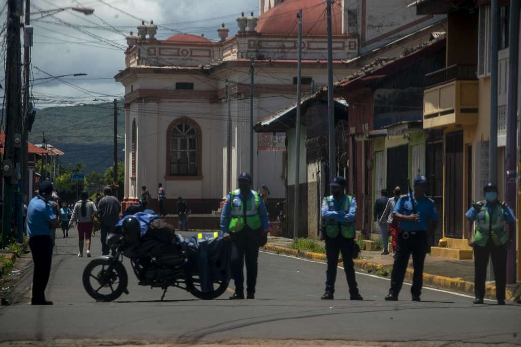 AME8702. MASAYA (NICARAGUA), 20/09/2022.- Agentes antidisturbios de la Policía Nacional vigilan la entrada de la iglesia de San Jerónimo, hoy durante la celebración de la bajada de la imagen en la ciudad de Masaya (Nicaragua). Cientos de agentes policiales, incluyendo miembros de operaciones especiales y antidisturbios, se acantonaron alrededor de la parroquia San Jerónimo, en Masaya, para hacer cumplir con la prohibición de las festividades establecida por la Policía Nacional y divulgada por la Arquidiócesis de Managua el pasado sábado. EFE/STR