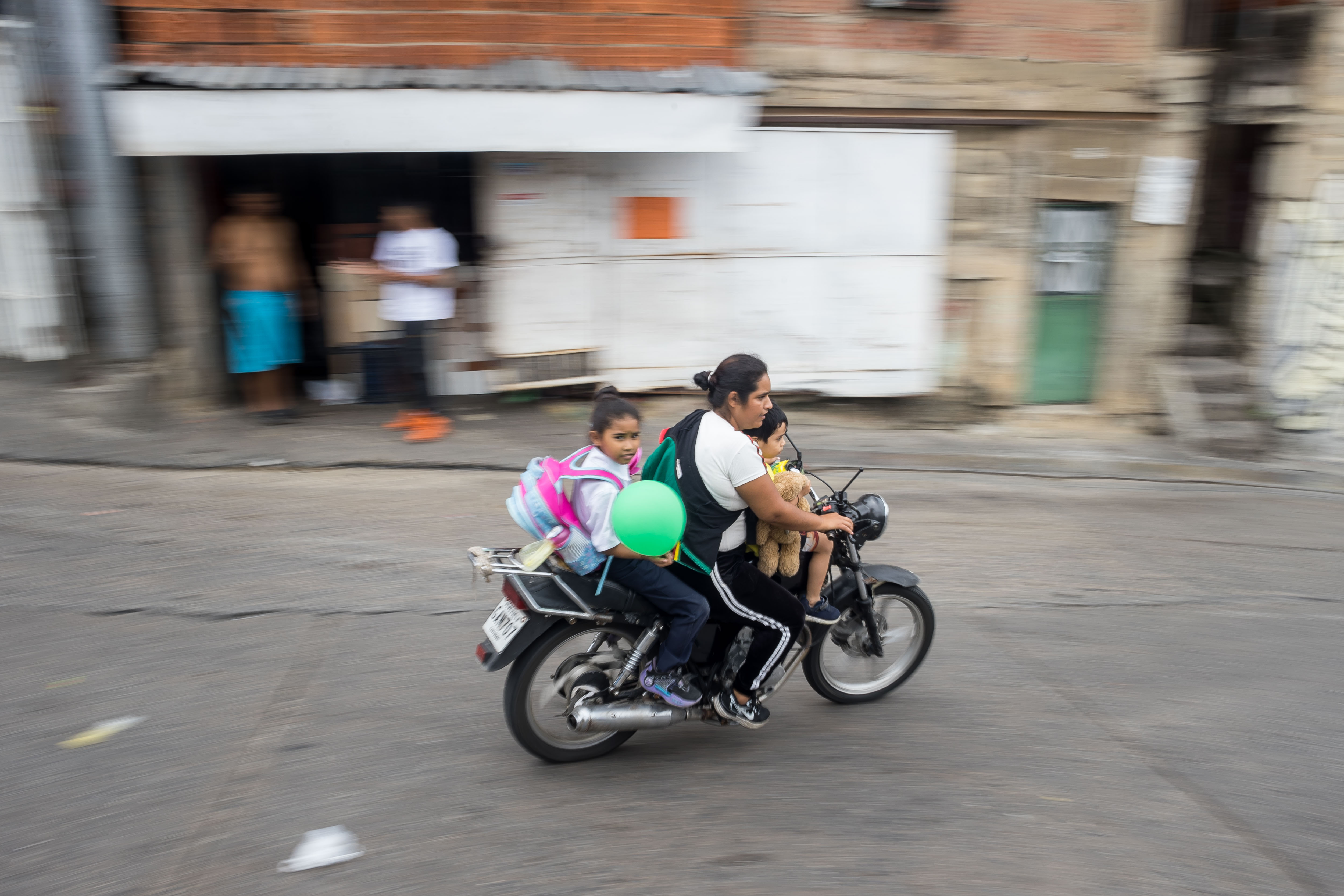 ACOMPAÑA CRÓNICA: VENEZUELA MUJERES AME2439. CARACAS (VENEZUELA), 22/08/2024.- Fotografía del 18 de junio de 2024 de Ronaldy Arteaga con sus hijos luego de una clase de mecánica para motorizadas en Petare, la barriada más grande de Caracas (Venezuela). Las alumnas del taller y las organizadoras reconocen que cada día hay más mujeres motoristas, por lo que -coinciden- es más necesario que nunca tener nociones de mecánica en un mundo en el que ellas llevan décadas luchando por el derecho a su autodeterminación y demostrando su manera de hacer tareas que antes les habían sido negadas. EFE/ Miguel Gutiérrez