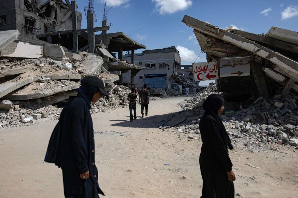 Khan Younis (---), 05/10/2025.- Internally displaced Palestinians walk past destroyed buildings in Khan Younis, southern Gaza Strip, 05 October 2025. According to the UN around 90 percent of the population or 1.9 million people in Gaza have been displaced since the start of the conflict. More than 67,000 Palestinians have been killed in the Gaza Strip since October 2023, according to the Palestinian Ministry of Health, and about 1,200 Israelis have been killed since the launch of an Israeli military campaign in response to a cross-border attack by Hamas on 07 October 2023. EFE/EPA/HAITHAM IMAD