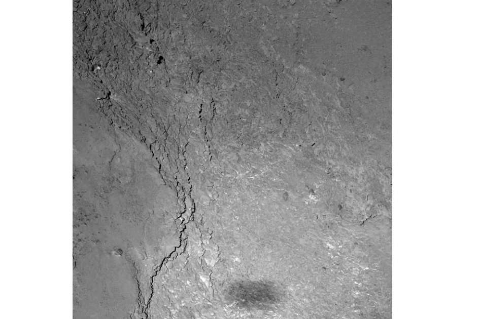 La sombra de Rosetta que se observa en la fotografía tiene una forma rectangular un poco difusa, con un tamaño mucho mayor al real de la nave. / AFP
