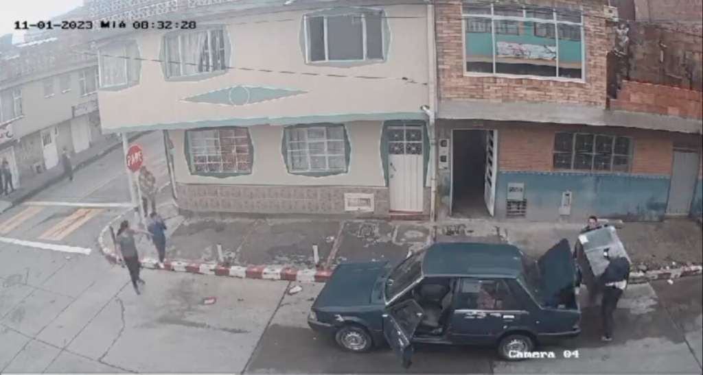 El momento en el que los ladrones intentan subir la lavadora robada en el baúl de su auto.Robo
