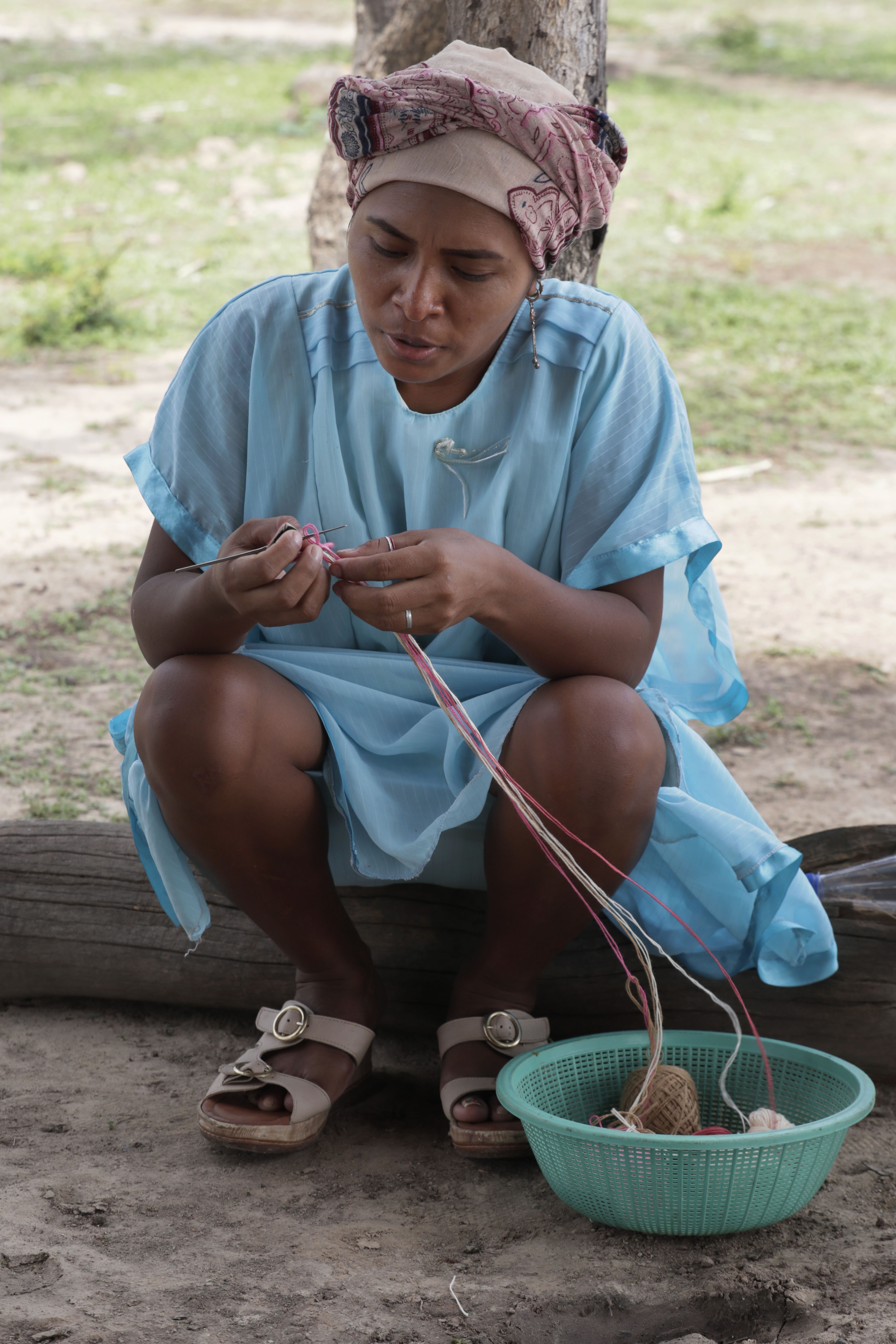 ACOMPAÑA CRÓNICA: COLOMBIA ARTESANÍAS - RIO400. RIOHACHA (COLOMBIA), 25/05/2022.- Fotografía fechada el 13 de mayo de 2022 que muestra una indígena wayúu mientras elabora un tejido en zona rural de Riohacha (Colombia). Las coloridas mochilas wayúu son de las artesanías más populares e identificativas de Colombia pero las mujeres indígenas que las tejen no reciben un pago justo por ellas, perpetuando un ciclo de pobreza y de hambre en el departamento de La Guajira. Si se trata de comprar una mochila a una wayúu en Riohacha, la capital departamental, los intermediarios no lo permiten porque dicen ser los dueños de la mercancía y exigen que se les pague a ellos, cuenta en una entrevista con Efe Sandra Guillot, coordinadora del Banco de Hilos, una iniciativa que busca que las mujeres reciban la compensación que merecen. EFE/ Carlos Ortega