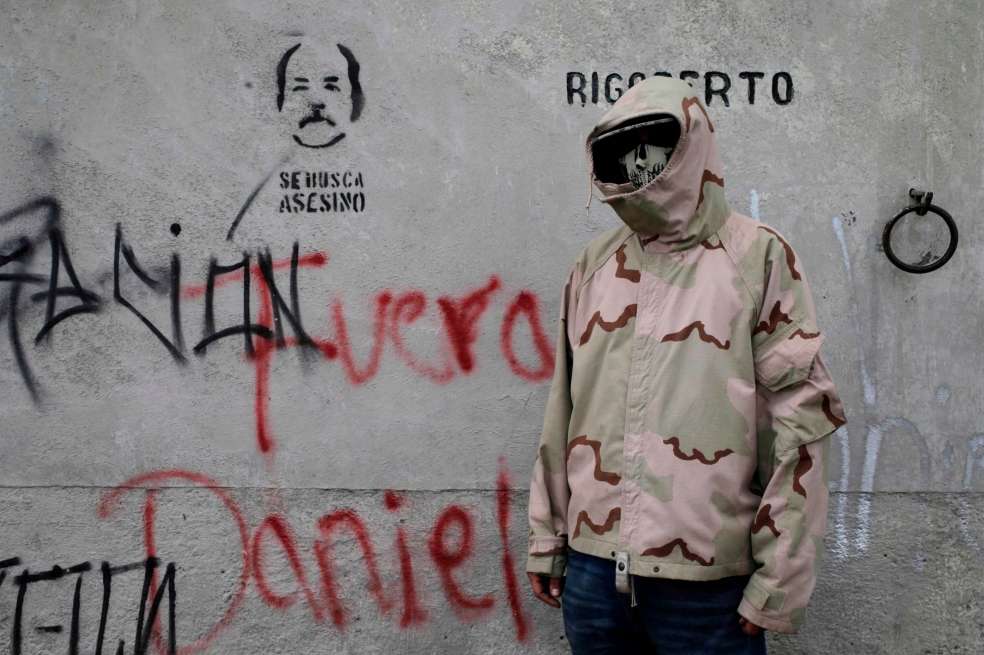 Un manifestante posa al lado de un grafiti contra Daniel Ortega. / AFP